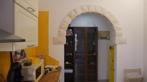 eine Küche mit einem Torbogen in einem Zimmer in der Unterkunft Rifugio di Sibir in Selva di Fasano