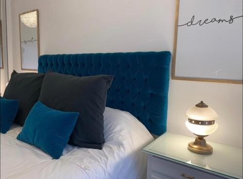 Bett mit blauem Kopfteil und einer Lampe auf dem Tisch in der Unterkunft Exquisito 2 ambientes en Palermo Soho in Buenos Aires