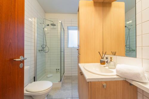 a bathroom with a toilet and a sink and a shower at Day Dream Soleyjargata Rooms & Apartments in Reykjavík