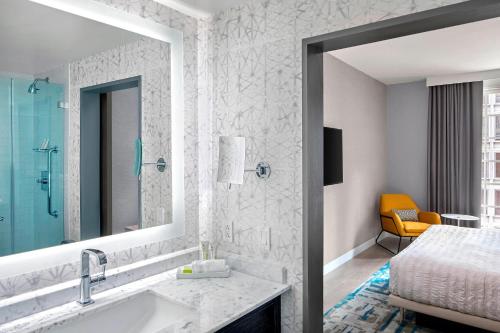 a bathroom with a sink and a bed and a mirror at Le Meridien Philadelphia in Philadelphia