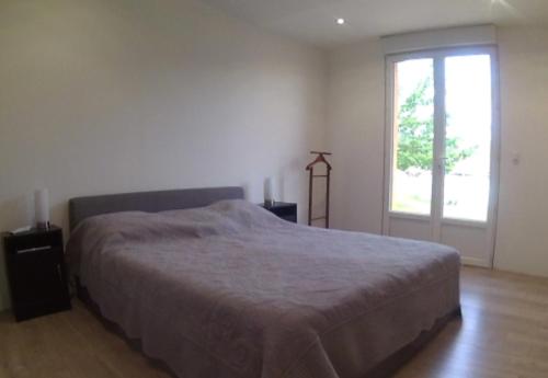 une chambre avec un grand lit et une fenêtre dans l'établissement Maison Les Cailloux, à Beaucaire