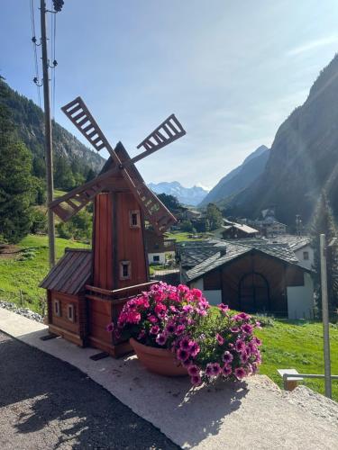 a windmill and flowers in a pot on a hill at Gemütliche Wohnung mit Bergblick in Herbriggen