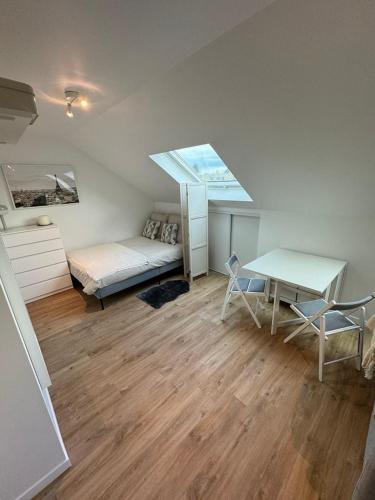 een slaapkamer met een bed, een bureau en een tafel bij Studio Saint Cyr in Saint-Cyr-lʼÉcole