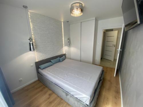 - une chambre avec un grand lit dans l'établissement ApartamentAugust, à Zielona Góra