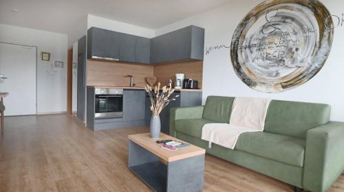 瓦瑟堡的住宿－DaSalvatore，客厅配有绿色沙发和桌子