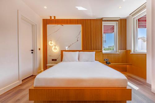 ein Schlafzimmer mit einem großen Bett und zwei Fenstern in der Unterkunft Dulcet Hotel in Antalya