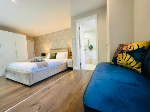 ロンドンにあるStylish, modern appartment in Central Londonのベッドルーム1室(ベッド2台、青いソファ付)