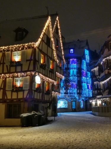 um edifício iluminado com luzes de Natal em Chambre dans appartement em Colmar