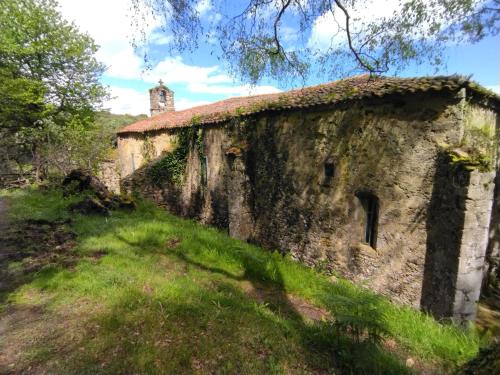 an old stone building with a tower in the background at Su3ño Cántabro apto en Unquera in Unquera