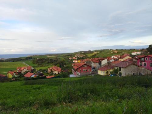 a village on a hill with green grass and houses at Su3ño Cántabro apto en Unquera in Unquera