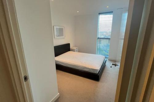 um pequeno quarto com uma cama num quarto em Cozy Living with Balcony View em Croydon