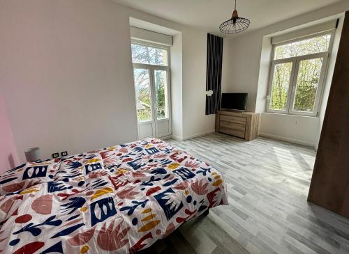 a bedroom with a bed with a colorful comforter at Océane 100m2 dans demeure Bourgeoise in Beaucourt