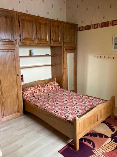 a bedroom with a bed with wooden cabinets at Lou Raspaillou in Issigeac