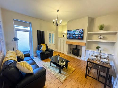 a living room with a couch and a table at Whitley Haven, Luxury Seaside Apartment in Whitley Bay
