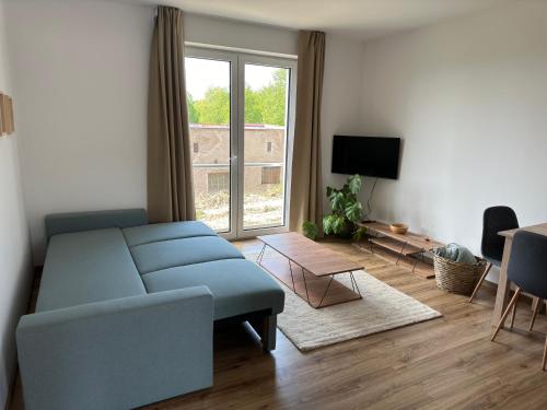 a living room with a blue couch and a window at Apartmán Anna in Nové Město nad Metují