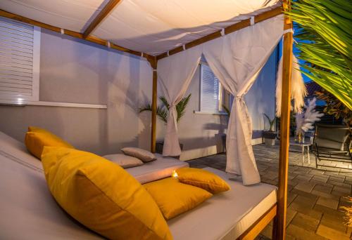 a bed with yellow pillows on it in a room at House with pool Ledenko in Biograd na Moru