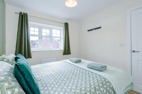 a bedroom with a bed with blue pillows on it at Modern Semi detached in a quiet location, Driveway parking in Ewloe