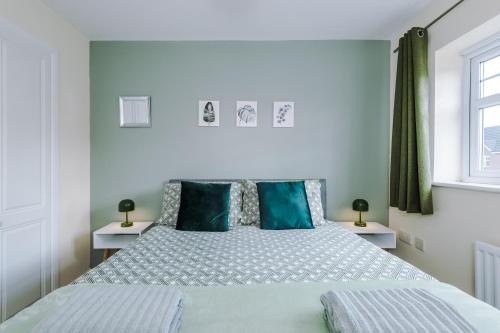 ein Schlafzimmer mit einem großen Bett mit blauen Kissen in der Unterkunft Modern Semi detached in a quiet location, Driveway parking in Ewloe