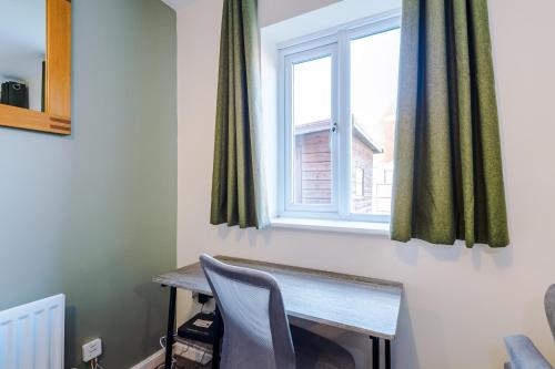a desk with a chair in front of a window at Modern Semi detached in a quiet location, Driveway parking in Ewloe