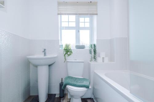 een witte badkamer met een toilet en een wastafel bij Modern Semi detached in a quiet location, Driveway parking in Ewloe