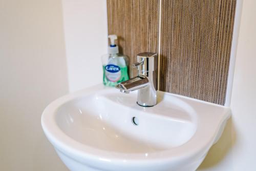 a white sink with a faucet in a bathroom at Modern Semi detached in a quiet location, Driveway parking in Ewloe