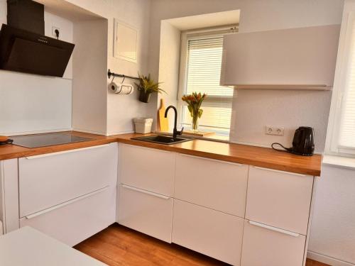 a kitchen with white cabinets and a sink at Traumhaft moderne Ferienhaus-Tiny House in 78554 Aldingen in Aldingen