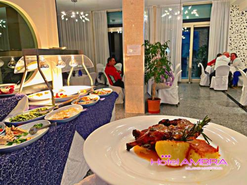 a table with a plate of food on it at HOTEL AMBRA - Fronte Mare - Vicinissimi al Centro in Milano Marittima