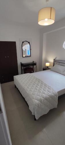 Un dormitorio con una gran cama blanca y una ventana en Φωλιά en Olympos