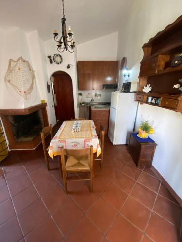 a kitchen and dining room with a table and a refrigerator at Casetta Marina Residence in Santa Luria