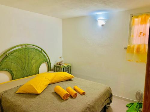 um quarto com uma cama com duas almofadas amarelas em La maison en jaune em Limpiddu