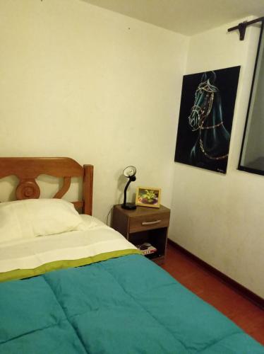 1 dormitorio con 1 cama y una foto de un caballo en la pared en Linda habitación cerca al mar, en Lima