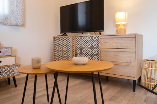 a living room with a table and a tv on a dresser at Cosy Cottage in Stalida