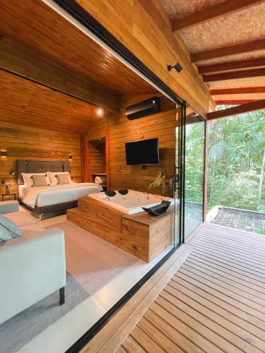 um quarto com uma cama e uma televisão na parede em Cabana equipada em meio à natureza em Pomerode em Pomerode