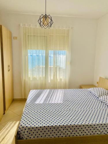 um quarto com uma cama grande e uma janela em Eden Home em Durrës