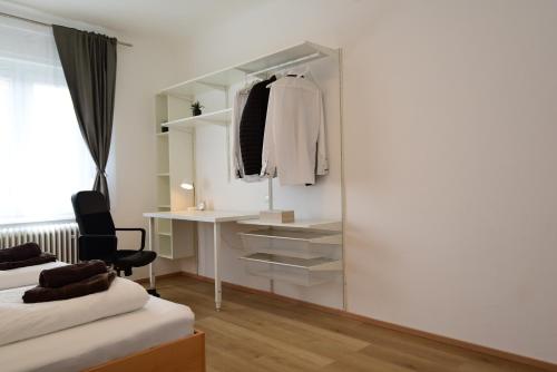 ウンタープレムシュテッテンにあるPM-APART Premstättenのベッド2台、デスク、鏡が備わる客室です。