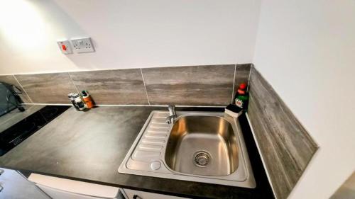 a kitchen sink with two bottles on the counter at Premier Nottingham Studios - Burford Road in Nottingham