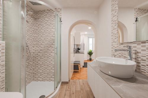 a white bathroom with a sink and a shower at Studio apartment in the heart of magic Piran in Piran