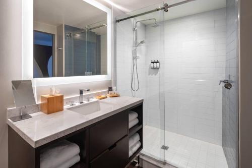 a bathroom with a sink and a shower at The CURRENT Hotel, Autograph Collection in Tampa