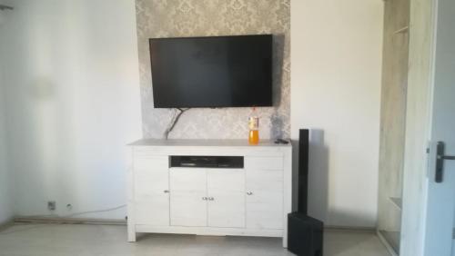 Mieszkanie w Tucholi في توكولا: خزانة بيضاء عليها تلفزيون