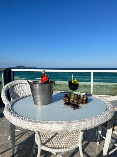 a table on a chair with a drink on it at Central Praias III in Cabo Frio
