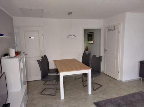 uma sala de jantar com uma mesa de madeira e cadeiras em Ferienhaus Oscar em Ahlbeck