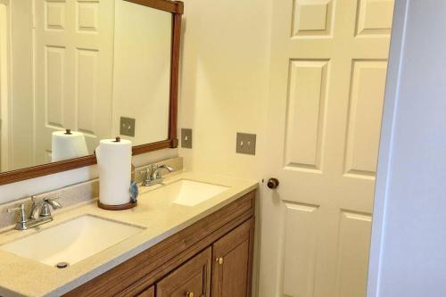 a bathroom with two sinks and a mirror at Sea Island Seclusion Marsh View with Beach Pass in St. Helena Island