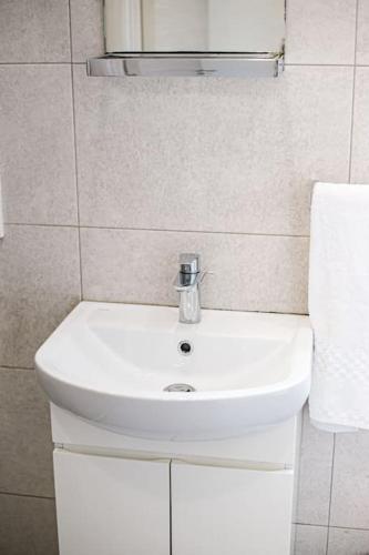 a bathroom with a white sink and a mirror at Birzebbuga -Two Bed Penthouse in Birżebbuġa