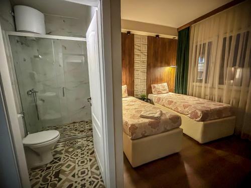 y baño con 2 camas, aseo y ducha. en Calla Bella Rooms & Snack Bar, en Skopje