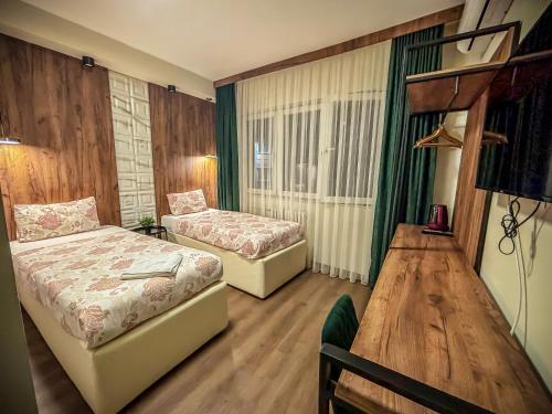 a hotel room with two beds and a table at Calla Bella Rooms & Snack Bar in Skopje