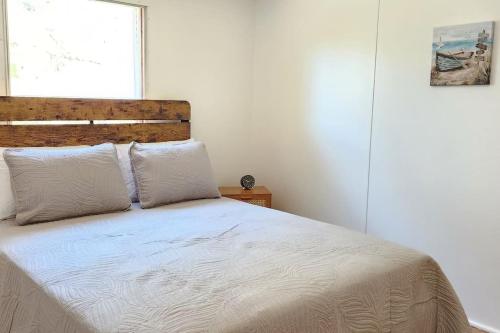 a bedroom with a bed with white sheets and a window at Sea Island Seclusion Marsh View with Beach Pass in St. Helena Island