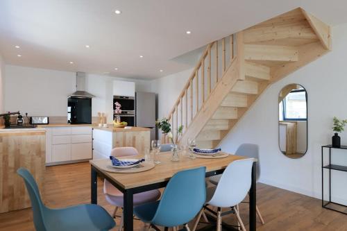 une cuisine et une salle à manger avec une table en bois et des chaises bleues dans l'établissement Maison proche gare de Guingamp, à Ploumagoar