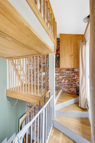 - un escalier dans une maison avec un mur en briques dans l'établissement Lovely apt near Paris/Stade de France, à Saint-Denis