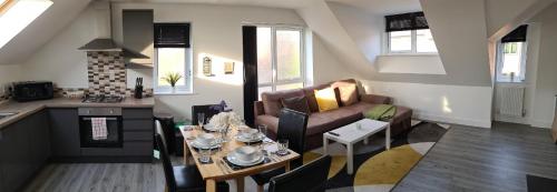 eine Küche und ein Wohnzimmer mit einem Tisch und einem Sofa in der Unterkunft SAV Apartments Nottingham Road Loughborough - 2 Bed Apartment in Loughborough