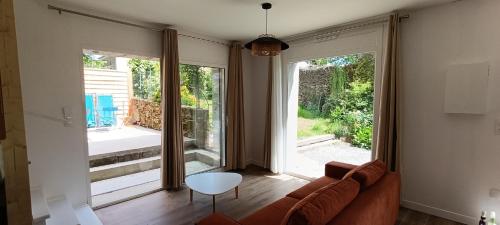 sala de estar con sofá y ventana grande en Maison Irondas, en Saint-Pierre-dʼAurillac